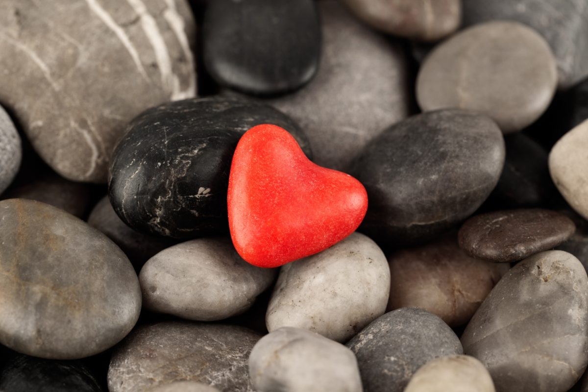 Red heart rock in a sea of different colored rocks