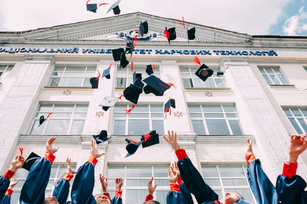 Graduates throwing their graduation cap in the air.