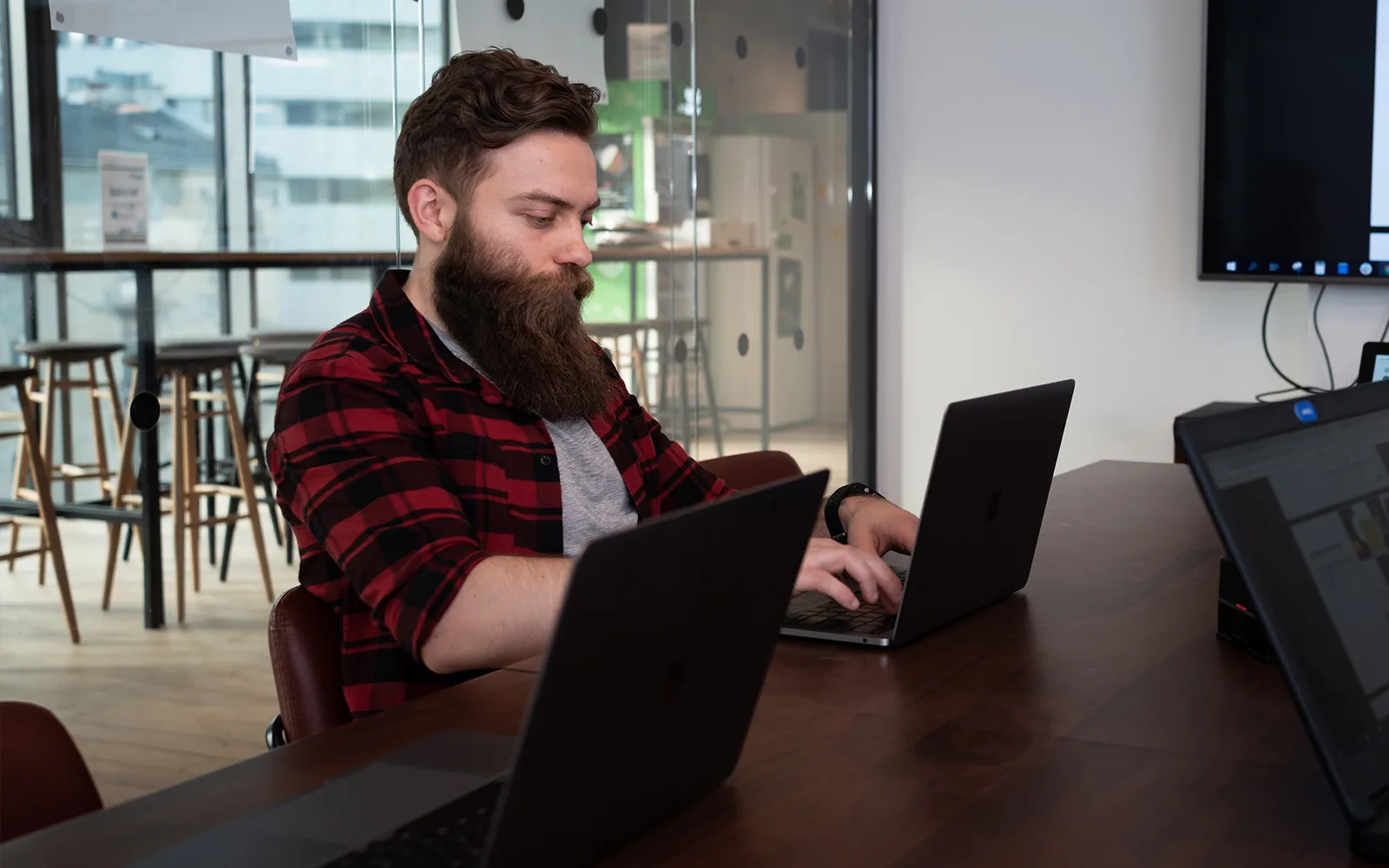 guy with beard sitting with a laptop in office