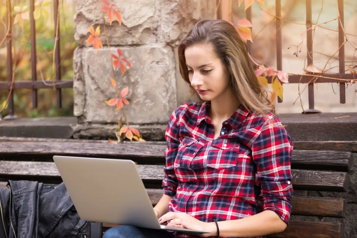Woman with a laptop on a bench