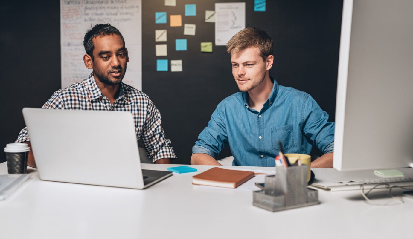 Two men in front of a laptop